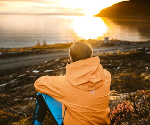 A serene outdoor scene with a person meditating at sunrise.