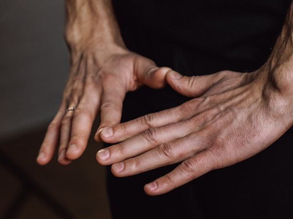 Close-up of a person's hands in a meditative mudra gesture.